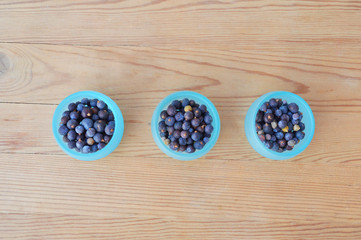 Healthy dried berries in a turquoise glass cup on the wooden table