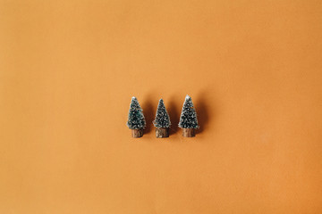 Tree toy Christmas fir-trees on ginger background. Flat lay, top view Christmas / New Year minimal...