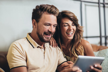 Flirting couple in cafe using digital tablet