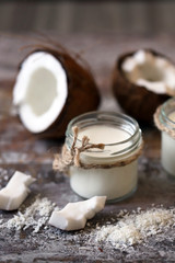 Jars of coconut milk, coconut flakes, coconut. Coconut milk extraction. Vegan milk. Selective focus. Macro.