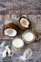 Fototapeta na wymiar Jars of coconut milk, coconut flakes, coconut. Coconut milk extraction. Vegan milk. Selective focus. Macro.