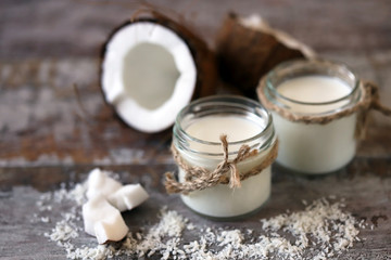Obraz na płótnie Canvas Jars of coconut milk, coconut flakes, coconut. Coconut milk extraction. Vegan milk. Selective focus. Macro.