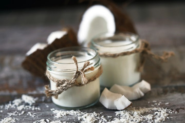 Jars of coconut milk, coconut flakes, coconut. Coconut milk extraction. Vegan milk. Selective focus. Macro.