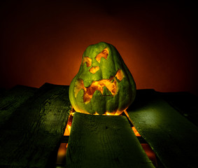 Scary Halloween pumpkins on wood in a spooky place at night. Poster concept.
