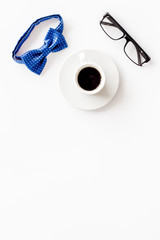 Father's Day or men's birthday concept. Bow tie, glasses and coffee on white background top view frame copy space