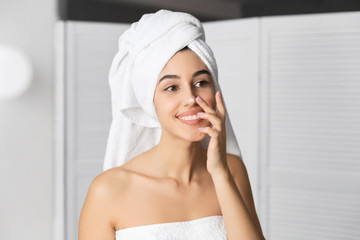 Cheerful Girl Applying Face Cream On Nose In Bathroom