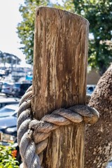 Wooden piling post with rope in a marina 
