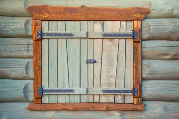 Old and restored log house shutter close up
