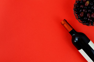 Bottle of red wine near bunch of grapes