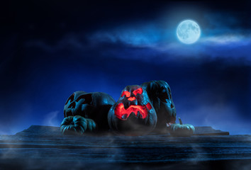 Scary Halloween pumpkins on wood in a spooky place at night. Poster concept.