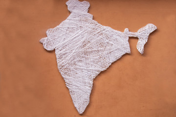 Indian map made of silk thread on plane brown wall