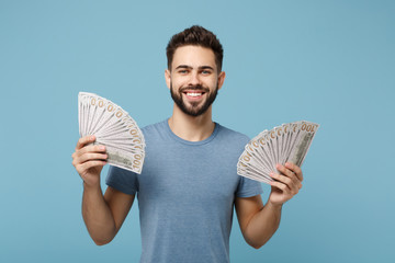 Young smiling man in casual clothes posing isolated on blue background, studio portrait. People...