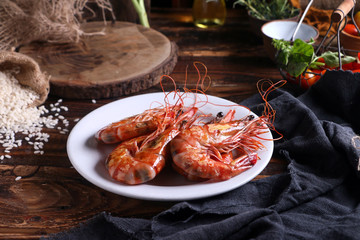 Plate of red King prawns on table in rustic kitchen