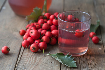 Hot tea from hawthorn berries in transparent glasses on a wooden table