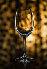 Glass wine glass stands on glass on yellow background