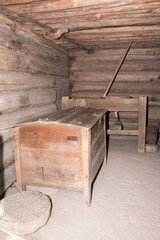 An ancient chest for storing flour , grain. Hand made wooden mill for flour  production from grain for bread making in European village country side place.The ancient quern stone hand mill with grain