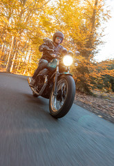 Moto racer riding on mountain road during sunset, blurred motion travel to Europe.