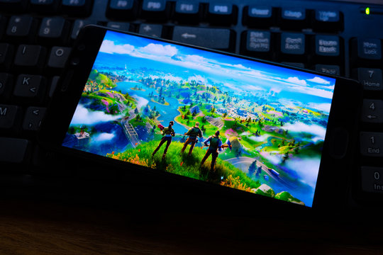 Kostanay, Kazakhstan, October 15, 2019.Mobile phone on the background of the keyboard, with the logo of the popular game fortnite 2, from Epic Games.
