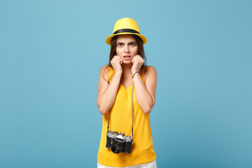 Traveler tourist woman in yellow summer casual clothes hat with photo camera isolated on blue background. Female sad passenger traveling abroad to travel on weekends getaway Air flight journey concept