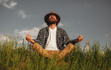 Bearded male meditating in nature
