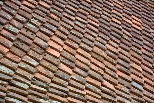 Antique ceramic multi-colored roof tiles. Background image of terracotta roof tiles closeup.