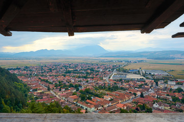 Fototapeta na wymiar Panorama of the historic city center from the balcony of the medieval fortress Rasnov, Romania. City landscape of the ancient town.