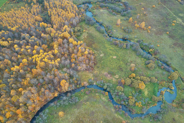 Aerial view with a drone. Winding river with autumn forest, top view