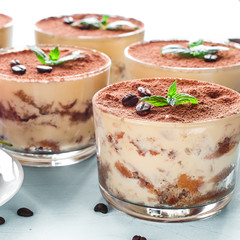 Tiramisu in the glass decorated whith mint on the wooden background