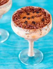 italian dessert tiramisu in an elegant cocktail glass, the concept of sweet life, luxury, delicious food