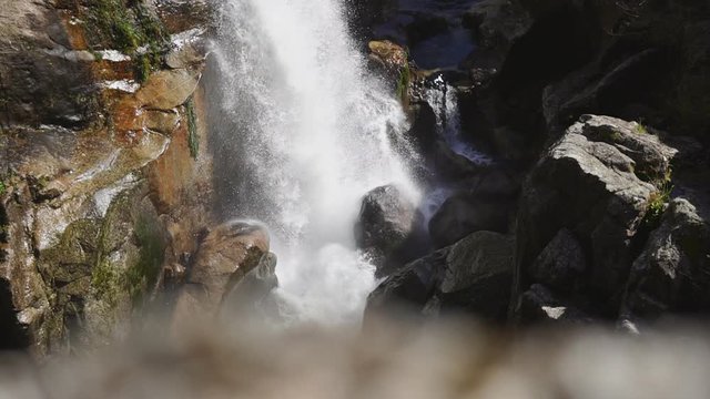 Dramatic view of waterfall cascade in forest with rocks