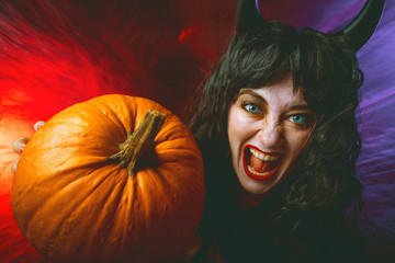Gruselige frau mit Halloween Kürbis  auf einem dunkelem Hintergrund, Halloween Party