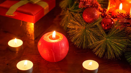 Closeup background with burning candles, Christmas wreath and presents