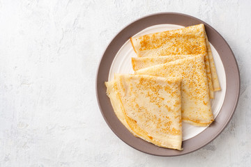 Crepes on plate on white concrete background. Top view. Copy space.