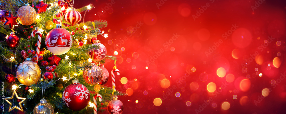 Wall mural christmas tree with ornament and bokeh lights in red background