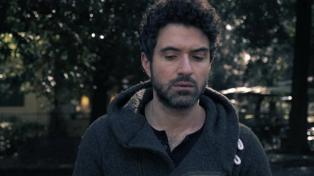 Thoughtful confident attractive man walking alone in the park.Thoughts, problems