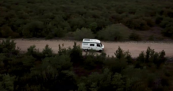 camper caravan drives offroad in the backcountry on gravel road