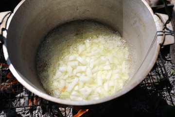 Frying onions in oil in cauldron