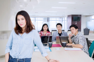 Fototapeta premium Businesswoman gestures confidence near her team