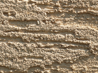 Brown background facade plaster . Monolithic plaster decorative backdrop. Single layer scraped cement plaster wallpaper. Bronze exterior building structure backdrop. Silica sand cement wall plaster