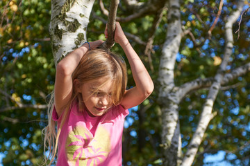 Child brave cute girl climbing on tree