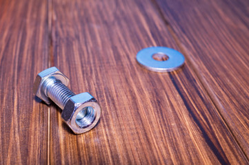 Metal bolt and nut on vintage wooden background