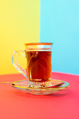 tea with saffron, crystal vintage teacup, crystal plate with golden design, silver spoon