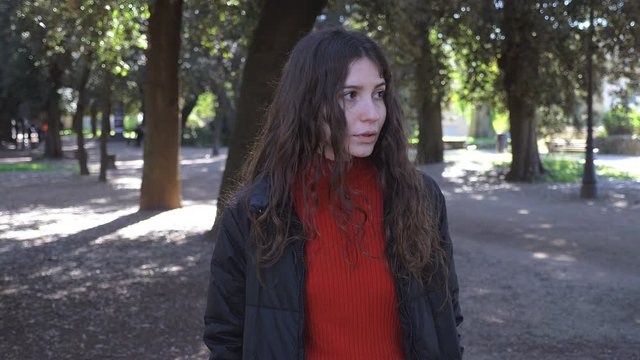 Sad depressed lonely young woman walking in the park.Love problems,depression