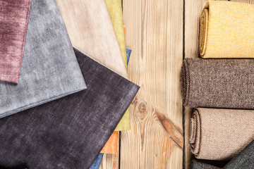 Arrangement from various colorful textile materials on wooden background