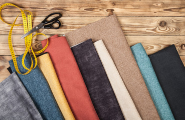 Samples of various colorful textile materials on a wooden background