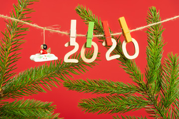 Christmas composition with wooden figures 2020. Figures hang on clothespins on a twine with a...