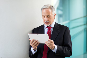 Senior manager using a digital tablet outdoor