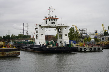 Gdansk, Poland - September 2019: View of the Gdansk Shipyard, shipyard. Gantry crane and moored ship. The tanker is moored in the port.