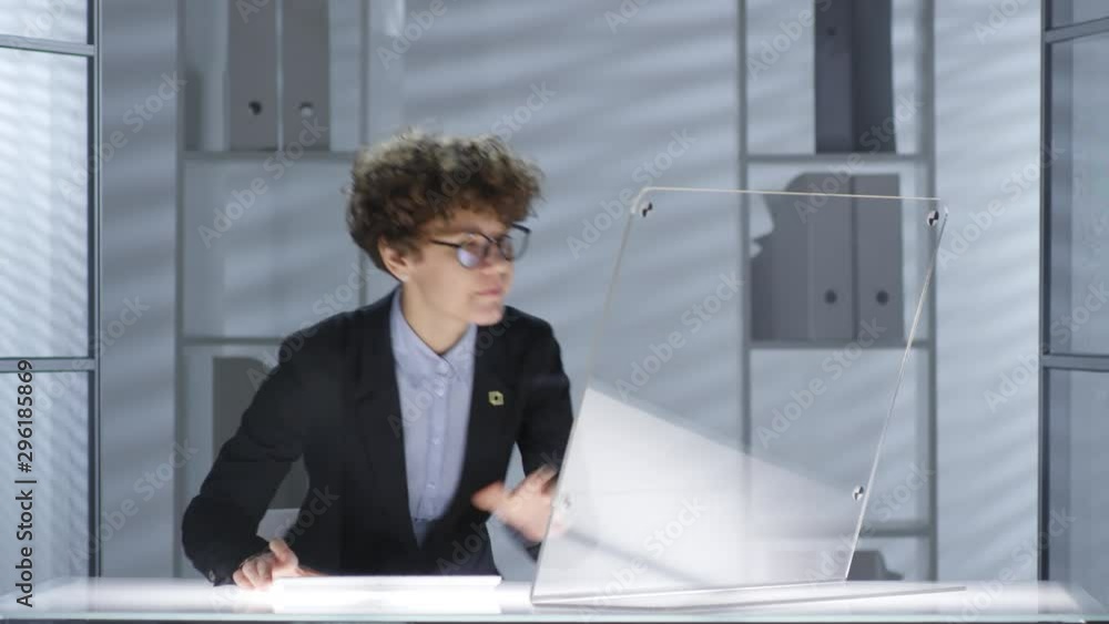 Poster businesswoman turning on illumination of modern office desk and typing on wireless computer with tra