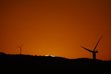 Fototapeta na wymiar solar disk sunset clouds aerogeneradores parque eolico carratraca malaga andalucia españa